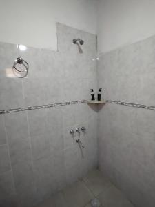 a bathroom with a shower with two bottles on a shelf at CABAÑAS LA LUCRECIA mono in Humahuaca