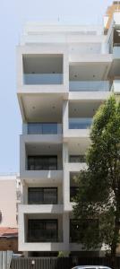 ein weißes Gebäude mit einem Baum davor in der Unterkunft Cubes Living Athens Goudi in Athen