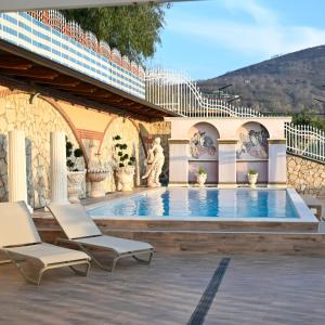 une piscine avec deux chaises et un bâtiment dans l'établissement Villa Eidos b&b, à Domicella