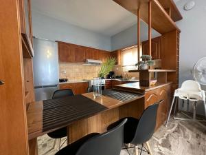 a kitchen with wooden cabinets and a kitchen island with chairs at W Pearl Suite in Nea Peramos