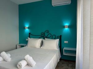 W Pearl Suite في ني بيراموس: غرفة نوم زرقاء مع سرير مع وسائد بيضاء