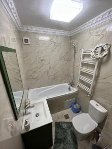 uma casa de banho com um lavatório, um WC e uma banheira em LNB ApartHotel Traian em Constança