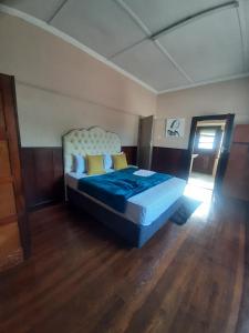 a bedroom with a bed with blue sheets and yellow pillows at tripple s guest house in Cape Town