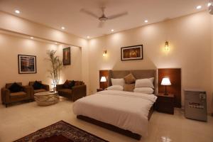 a bedroom with a bed and a living room at A One Hotel Clifton in Karachi
