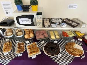 a table with different types of pastries and a microwave at Hotel Blumenau Centro in Curitiba