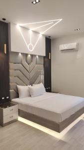 a bedroom with a large bed with lights on it at MidtownTahrirViewSuites in Cairo