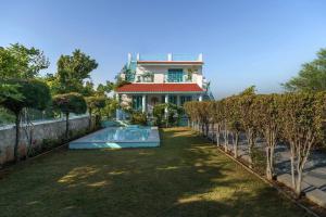 a house with a swimming pool in front of a yard at Thaharo 2 BHK Luxurious Villa in Udaipur in Thūr