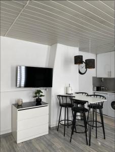 een keuken met een tafel en stoelen en een televisie bij Eiffel Tour - Cosy Parisien in Parijs +1 foto