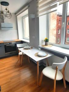 una cucina con tavolo e sedie bianchi in una stanza di Teodora B. Apartament a Liepāja