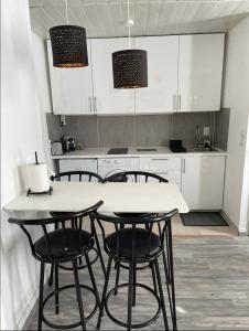 a kitchen with four chairs and a white table at Eiffel Tour - Cosy Parisien in Paris