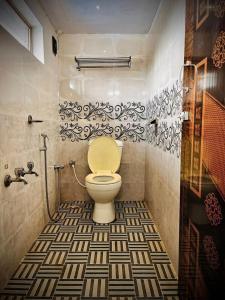 a bathroom with a toilet with a patterned floor at Brickhouse in Kodaikānāl