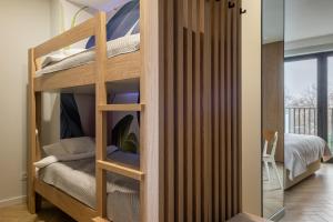 a bunk bed in a room with a glass door at AVAPARTS Apartament FAMILY in Jastarnia