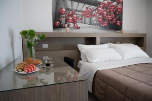 Un dormitorio con una cama y una mesa con un plato de pan. en Villa Eidos b&b, en Domicella