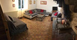a living room with a couch and a fireplace at Gite Bacchus in Baleyssagues