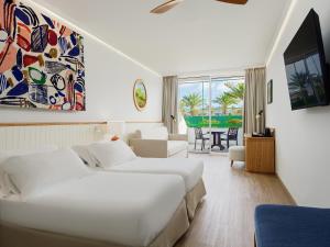 um quarto de hotel com duas camas e uma sala de estar em H10 Lanzarote Princess em Playa Blanca