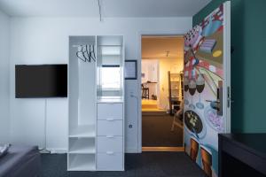 Zimmer mit einer Tür zu einem Zimmer mit einer Küche in der Unterkunft Kulukis Downtown Hostel in Nuuk
