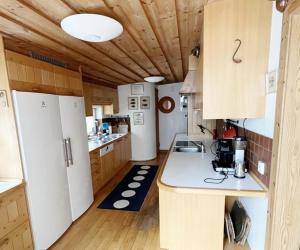 uma cozinha com electrodomésticos brancos e armários de madeira em Modern villa with sea view in Beddingestrand em Beddinge Strand