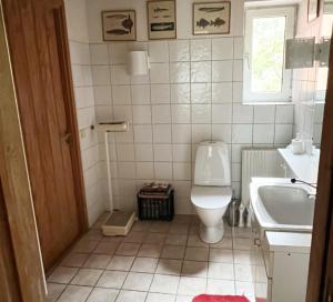 uma casa de banho branca com um WC e um lavatório em Modern villa with sea view in Beddingestrand em Beddinge Strand