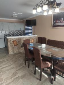 une salle à manger avec une table et des chaises ainsi qu'une cuisine dans l'établissement "У Пасічника" Котедж для сім'ї, à Yaremtche