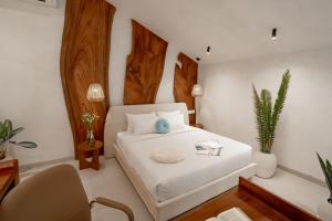 a bedroom with a white bed and a desk and a chair at Sunny Cuddles in Canggu