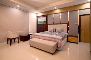 a bedroom with a bed and a chair and a table at Elite Villa in Duqm
