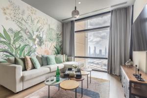 a living room with a couch and a large window at Frank Porter - Index Tower in Dubai