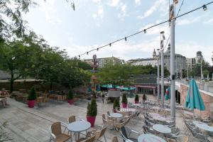 an outdoor patio with tables and chairs and people sitting at Little Americas Hillside Apartments in Budapest