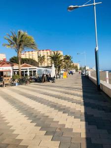 a boardwalk with palm trees and a street light at Apartamento Andaluz CARMA in Torrox Costa