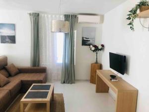 a living room with a couch and a tv at Apartamento Andaluz CARMA in Torrox Costa