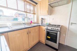 eine Küche mit einer Spüle und einem Herd Top-Backofen in der Unterkunft Pass the Keys Stylish 3 bedroom home with free parking in Nottingham