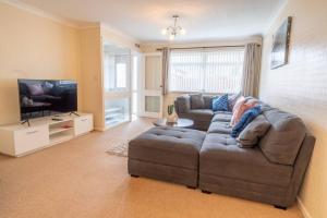 a living room with a couch and a flat screen tv at Pass the Keys Stylish 3 bedroom home with free parking in Nottingham