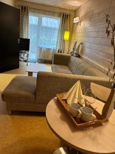 un soggiorno con un divano e un tavolo con bicchieri da vino di Agate Hotel a Ozolnieki