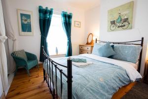 a bedroom with a bed and a chair and a window at Tilly Cottage, DurhamDales in Bishop Auckland