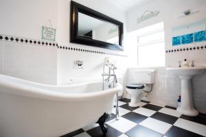a bathroom with a tub and a toilet and a sink at Tilly Cottage, DurhamDales in Bishop Auckland
