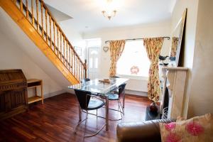 a dining room with a glass table and stairs at Tilly Cottage, DurhamDales in Bishop Auckland