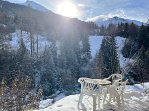 a table and chairs in the snow on a mountain at Leva des neiges in Lanslevillard