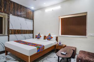 a bedroom with a bed and a table and a chair at FabHotel Perams Grand Inn in Kondapur