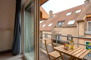 een balkon met een houten tafel en een raam bij Jette Expo Duplex Residence in Brussel