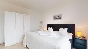 ein Schlafzimmer mit einem weißen Bett mit zwei Handtüchern darauf in der Unterkunft strandnahe FeWo mit Balkon, Residenz Bel Vital 37, Binz in Binz