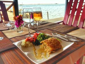 a plate of food on a table with wine glasses at Fagapa Lodge in Guilor