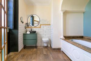 a bathroom with a tub and a toilet and a mirror at ibis Styles Dijon Sud Domaine De Beauregard 21600 Longvic in Dijon