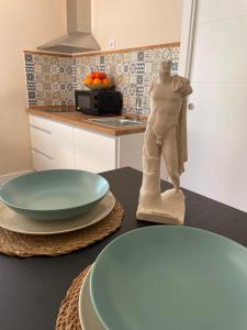 a table with a statue of a man in a kitchen at Pisito de la Lola Flores in Santiponce