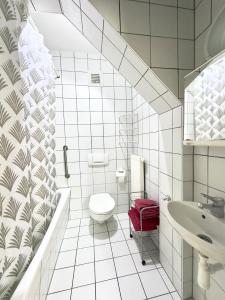 biała łazienka z toaletą i umywalką w obiekcie Picobello Pension w mieście Görlitz