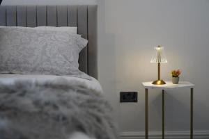 a bed with a pillow and a lamp on a side table at Modern spacious 6 bed in Central Plymouth with Parking in Plymouth