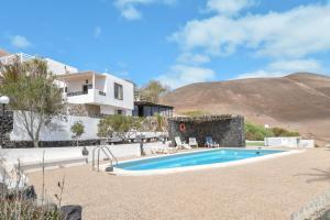 uma villa com uma piscina e uma casa em Finca La Calerita C em Yaiza