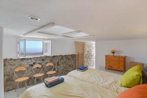 um quarto com uma cama, 2 cadeiras e uma janela em Finca La Calerita C em Yaiza