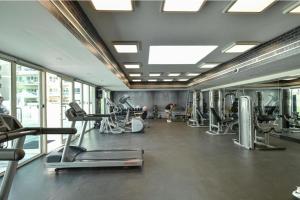 a gym with several treadmills and cardio machines at Charming 1BR in The Greens, Near Metro in Dubai