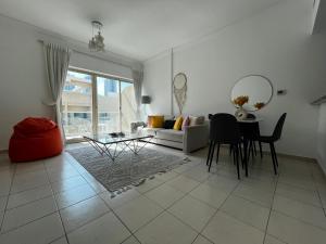 a living room with a couch and a table at Charming 1BR in The Greens, Near Metro in Dubai