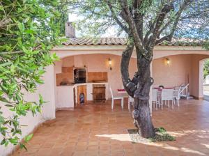 ein Haus mit einem Baum in der Mitte einer Terrasse in der Unterkunft Villa impressionniste * Jardin* Clim * Piscine * in Les Matelles