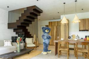 a large blue teddy bear standing in a living room at Sunny Cuddles in Canggu
